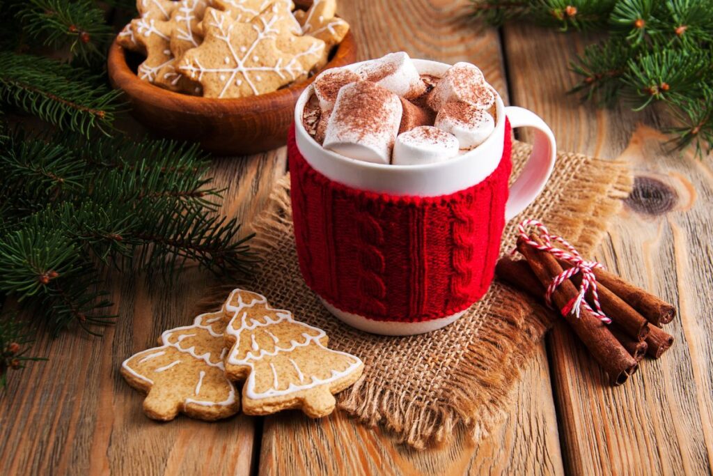 Mug of coffee in a red wrap with gingerbread Christmas biscuits